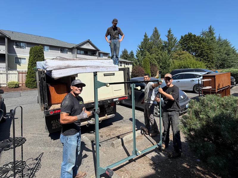 Classic Cleanouts crew loading furniture and mattresses into the truck for a junk removal job
